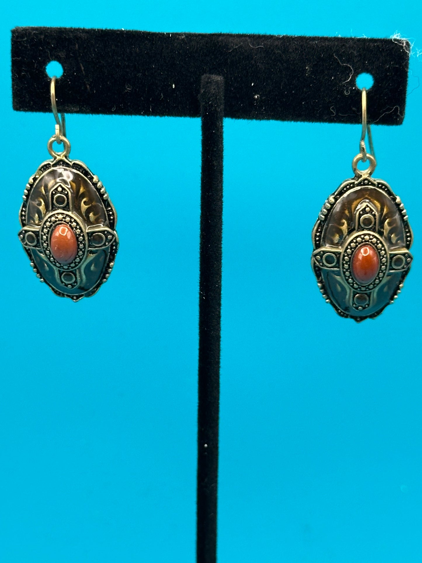 Carnelian-like stone and gold metal drop earrings on an ear wire