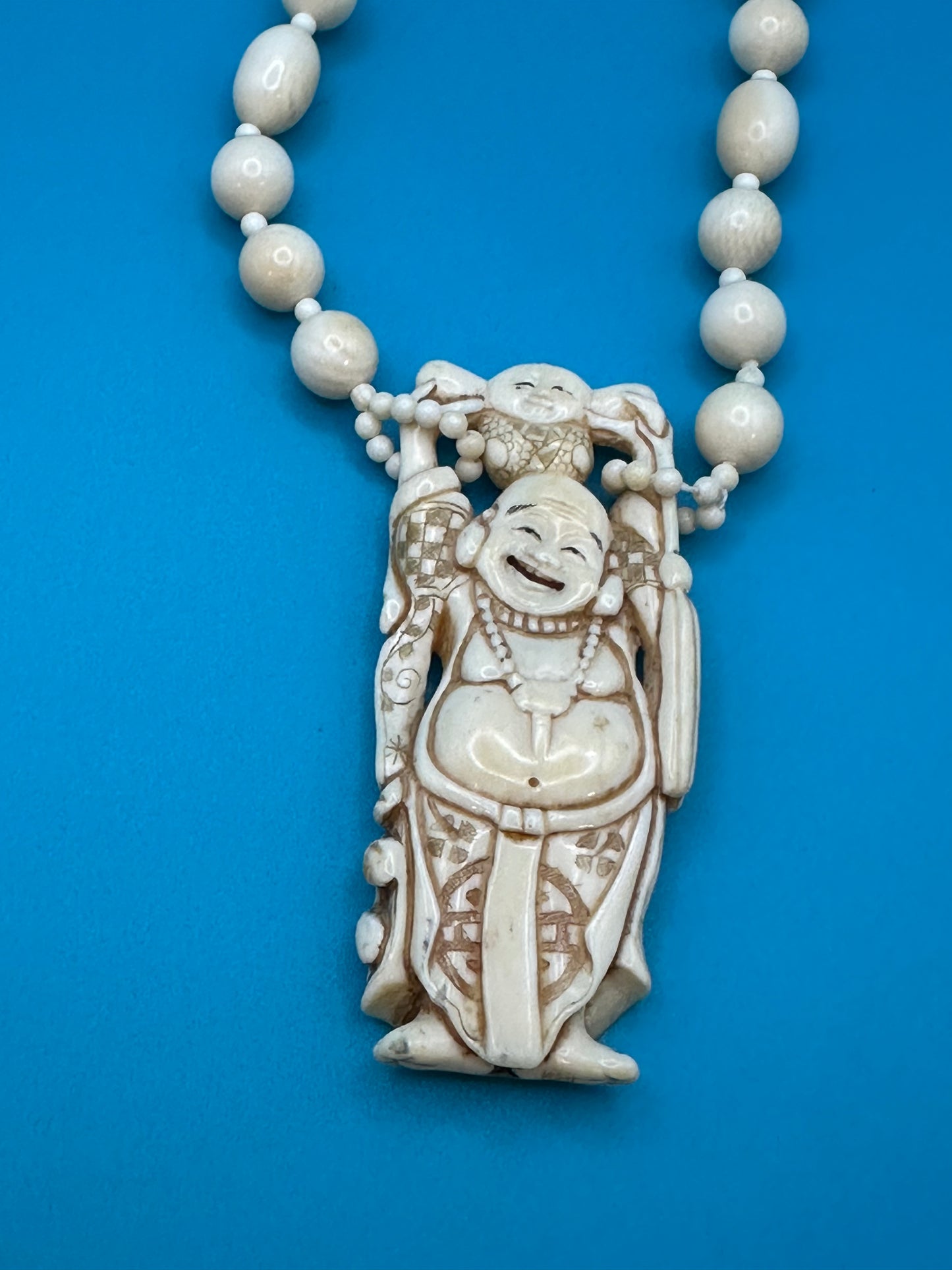 Authentic ivory necklace with carved and colored buddha charm