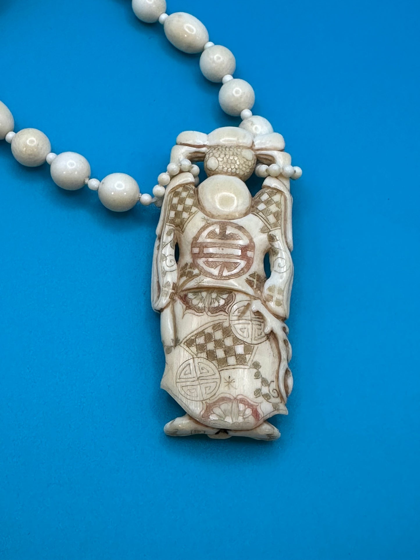 Authentic ivory necklace with carved and colored buddha charm