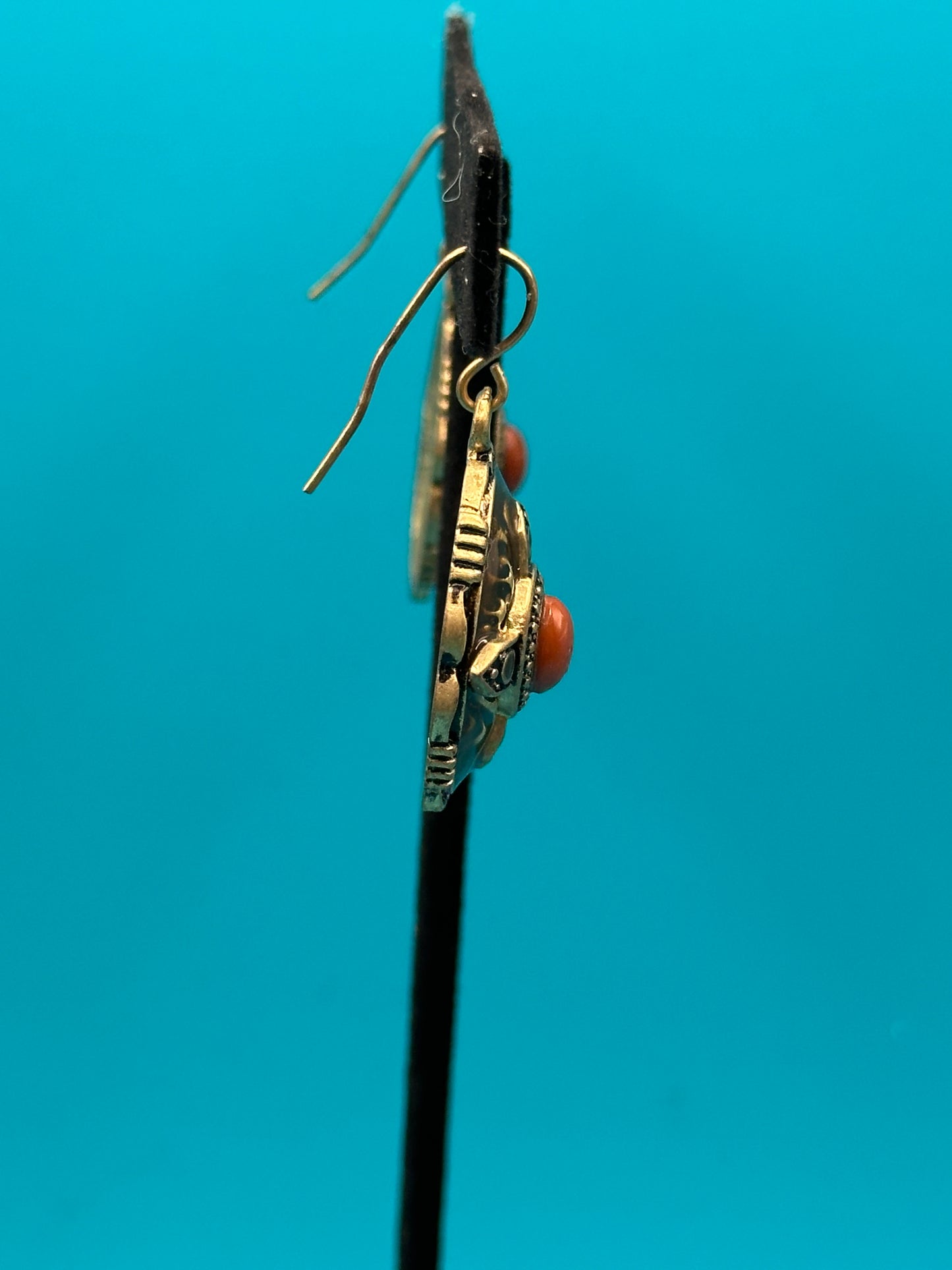 Carnelian-like stone and gold metal drop earrings on an ear wire